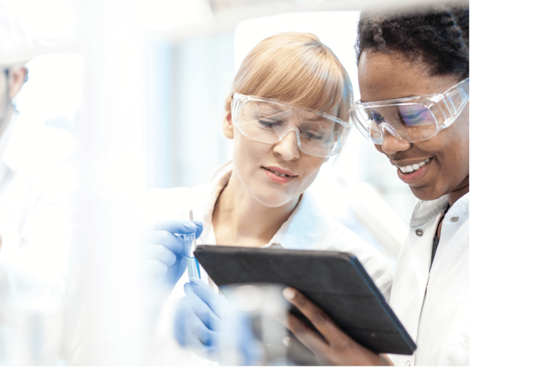 Scientists in a lab setting looking at a tablet