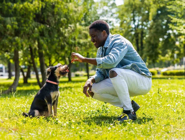 men giving a treat to his dog